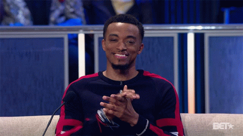 A Man Sitting In Front Of A Microphone With A Bet Logo On The Bottom GIF