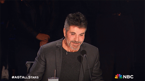 A Man Sitting In Front Of A Microphone With The Nbc Logo On The Bottom Right GIF
