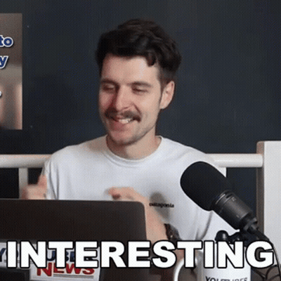 A Man Sitting In Front Of A Microphone With The Word Interesting Written On The Bottom GIF