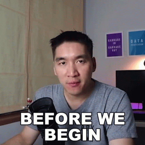 A Man Sitting In Front Of A Microphone With The Words " Before We Begin " On His Face GIF