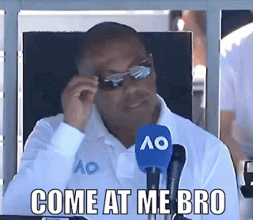 A Man Sitting In Front Of A Microphone With The Words Come At Me Bro GIF