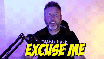 A Man Sitting In Front Of A Microphone With The Words " Excuse Me " On His Shirt GIF
