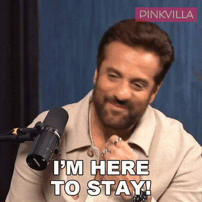 A Man Sitting In Front Of A Microphone With The Words I 'M Here To Stay Written On His Face GIF