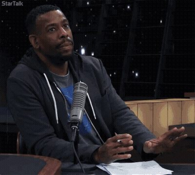 A Man Sitting In Front Of A Microphone With The Words I 'M Just Saying GIF