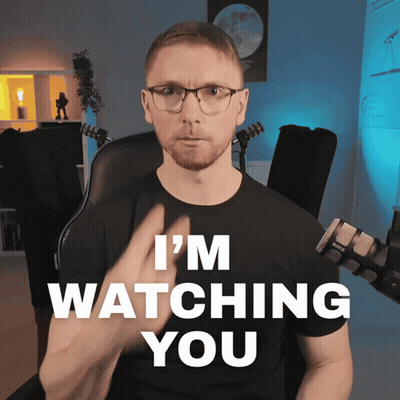 A Man Sitting In Front Of A Microphone With The Words I 'M Watching You Behind Him GIF