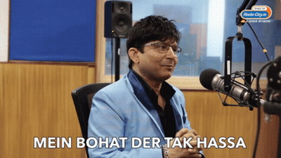 A Man Sitting In Front Of A Microphone With The Words Mein Bohat Der Tak Hassa Written Below Him GIF
