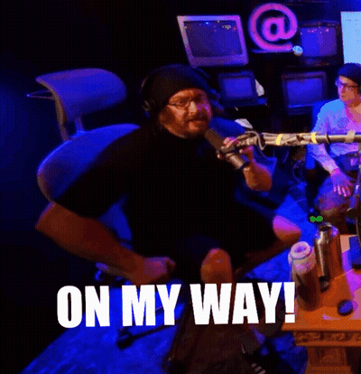 A Man Sitting In Front Of A Microphone With The Words On My Way Written On The Bottom GIF
