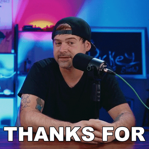 A Man Sitting In Front Of A Microphone With The Words Thanks For Written Underneath Him GIF