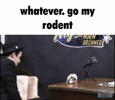 A Man Sitting In Front Of A Microphone With The Words " Whatever Go My Rodent " Written Above Him GIF