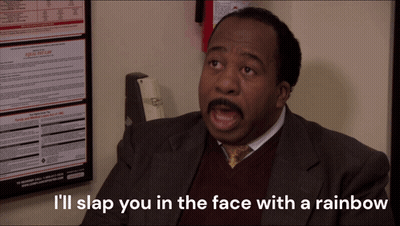 A Man Sitting In Front Of A Poster That Says I 'Ll Slap You In The Face With A Rainbow On It GIF