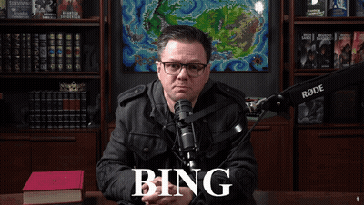 A Man Sitting In Front Of A Rode Microphone With The Word Bing On The Screen GIF