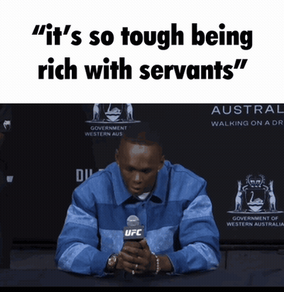 A Man Sitting In Front Of A Sign That Says ' It 'S So Tough Being Rich With Servants " GIF