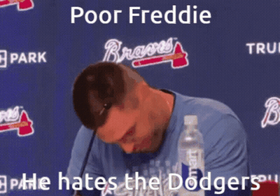 A Man Sitting In Front Of A Sign That Says " Poor Freddie " On It GIF