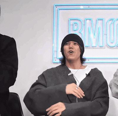 A Man Sitting In Front Of A Sign That Says Rmo On It GIF