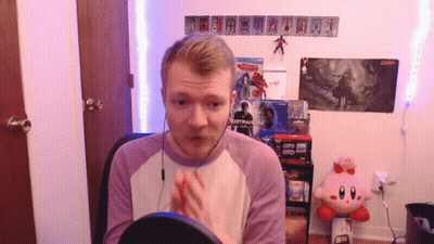 A Man Sitting In Front Of A Sign That Says ' Spiderman 2 ' On It GIF