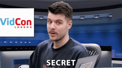 A Man Sitting In Front Of A Videocon London Sign GIF