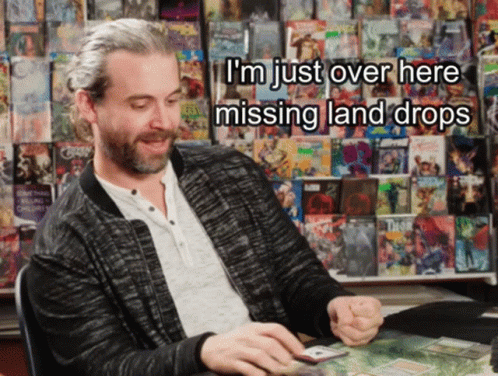 A Man Sitting In Front Of A Wall Of Comic Books With The Words I 'M Just Over Here Missing Land Drops Above Him GIF
