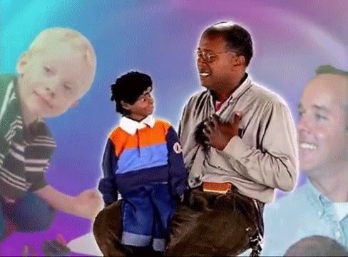 A Man Sitting Next To A Little Boy With The Letter Q On His Sweater GIF