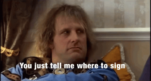 A Man Sitting On A Bed With The Words You Just Tell Me Where To Sign Behind Him GIF