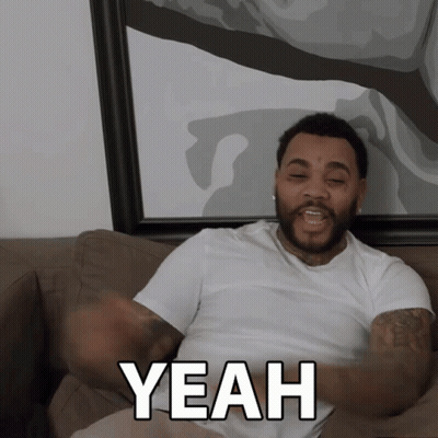 A Man Sitting On A Couch Says Yeah With His Arms Outstretched GIF