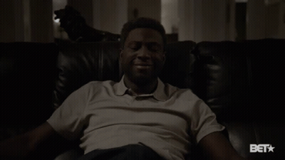A Man Sitting On A Couch With A Bet Logo On The Bottom GIF