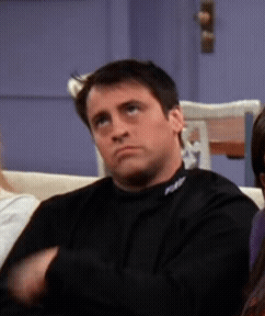A Man Sitting On A Couch With A Black Shirt On That Says Fox GIF