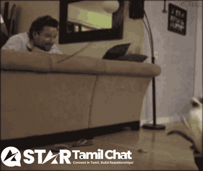 A Man Sitting On A Couch With A Laptop And A Star Tamil Chat Logo Behind Him GIF