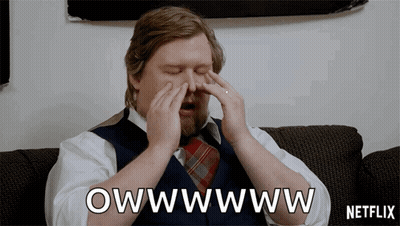 A Man Sitting On A Couch With His Eyes Closed And A Netflix Logo In The Background GIF