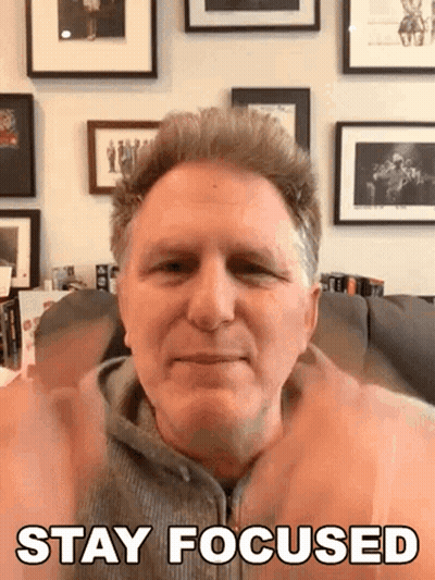 A Man Sitting On A Couch With His Hands Up And The Words Stay Focused Above Him GIF