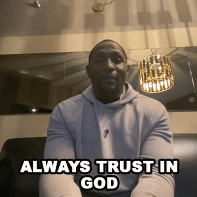 A Man Sitting On A Couch With The Words " Always Trust In God " Below Him GIF