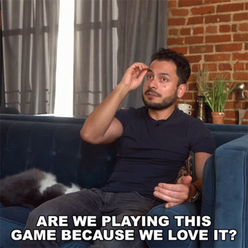 A Man Sitting On A Couch With The Words Are We Playing This Game Because We Love It Below Him GIF