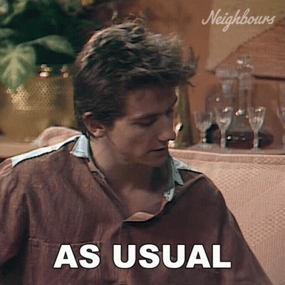 A Man Sitting On A Couch With The Words As Usual Written On The Screen GIF