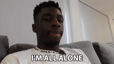 A Man Sitting On A Couch With The Words I 'M All Alone Written On His Shirt GIF