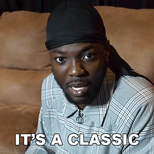 A Man Sitting On A Couch With The Words " It 'S A Classic " On The Bottom GIF