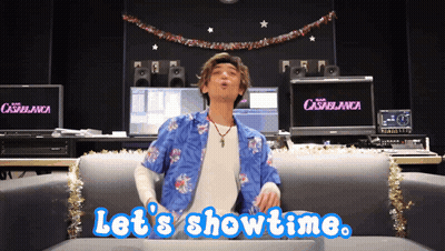 A Man Sitting On A Couch With The Words Let 'S Showtime GIF