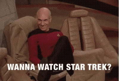 A Man Sitting On A Couch With The Words " Wanna Watch Star Trek " Written Below Him GIF