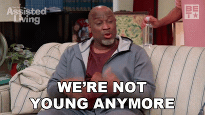 A Man Sitting On A Couch With The Words We 'Re Not Young Anymore GIF