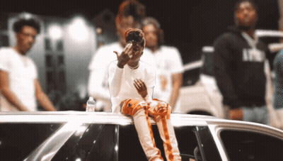 A Man Sitting On Top Of A Car Giving The Middle Finger To The Camera GIF