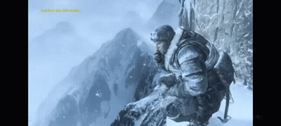 A Man Sitting On Top Of A Snow Covered Mountain Looking Out GIF