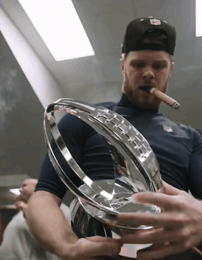 A Man Smoking A Cigar While Holding A Trophy In His Hands GIF