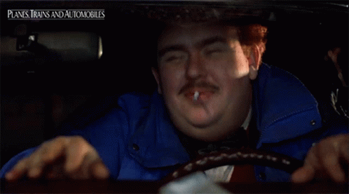 A Man Smoking A Cigarette In A Car With Planes Trains And Automobiles On The Bottom Right GIF