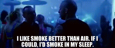 A Man Smoking A Cigarette In Front Of A Crowd Of People With The Words I Like Smoke Better Than Air GIF