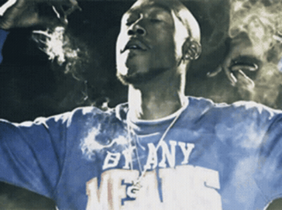 A Man Smoking A Cigarette Wearing A Shirt That Says By Any Means GIF