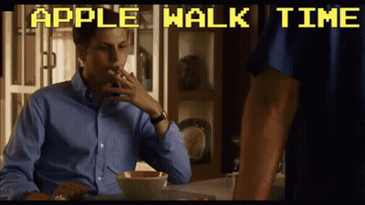 A Man Smoking A Cigarette While Sitting At A Table With The Words Apple Walk Time Above Him GIF