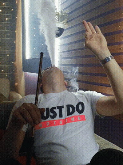 A Man Smoking A Hookah Wearing A Just Do Nothing Shirt GIF
