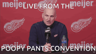 A Man Speaking Into A Microphone In Front Of A Meijer Logo GIF