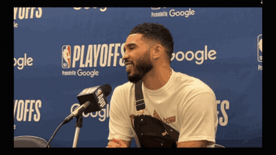 A Man Speaking Into A Microphone In Front Of A Wall That Says Playoffs On It GIF