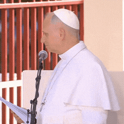 A Man Speaking Into A Microphone While Wearing A White Hat GIF