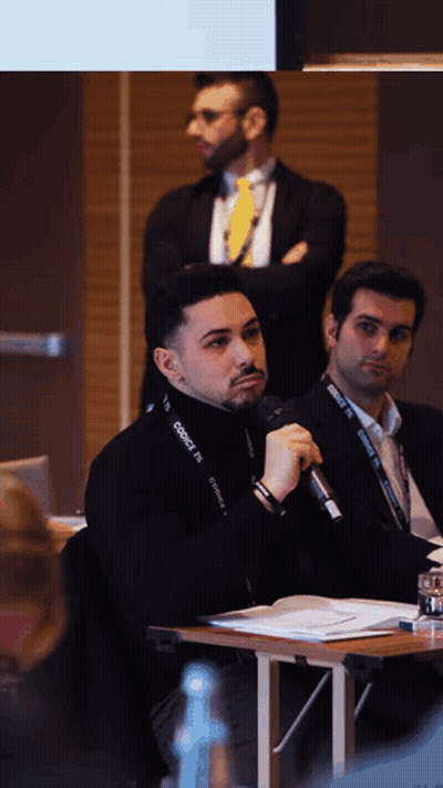 A Man Speaking Into A Microphone With A Lanyard Around His Neck That Says Connect GIF