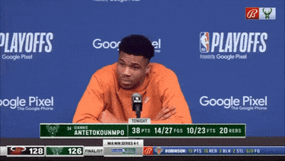 A Man Speaking Into A Microphone With Playoffs Written On The Screen Behind Him GIF